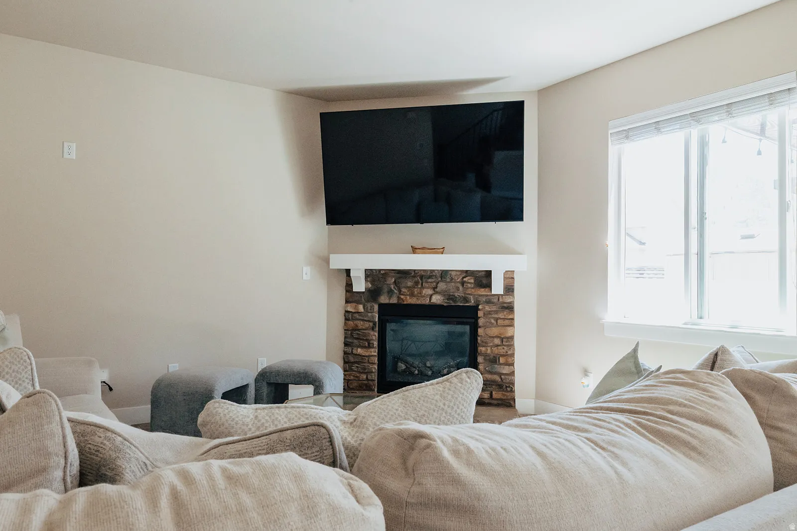 Corner fireplace with natural stone surround and white mantel