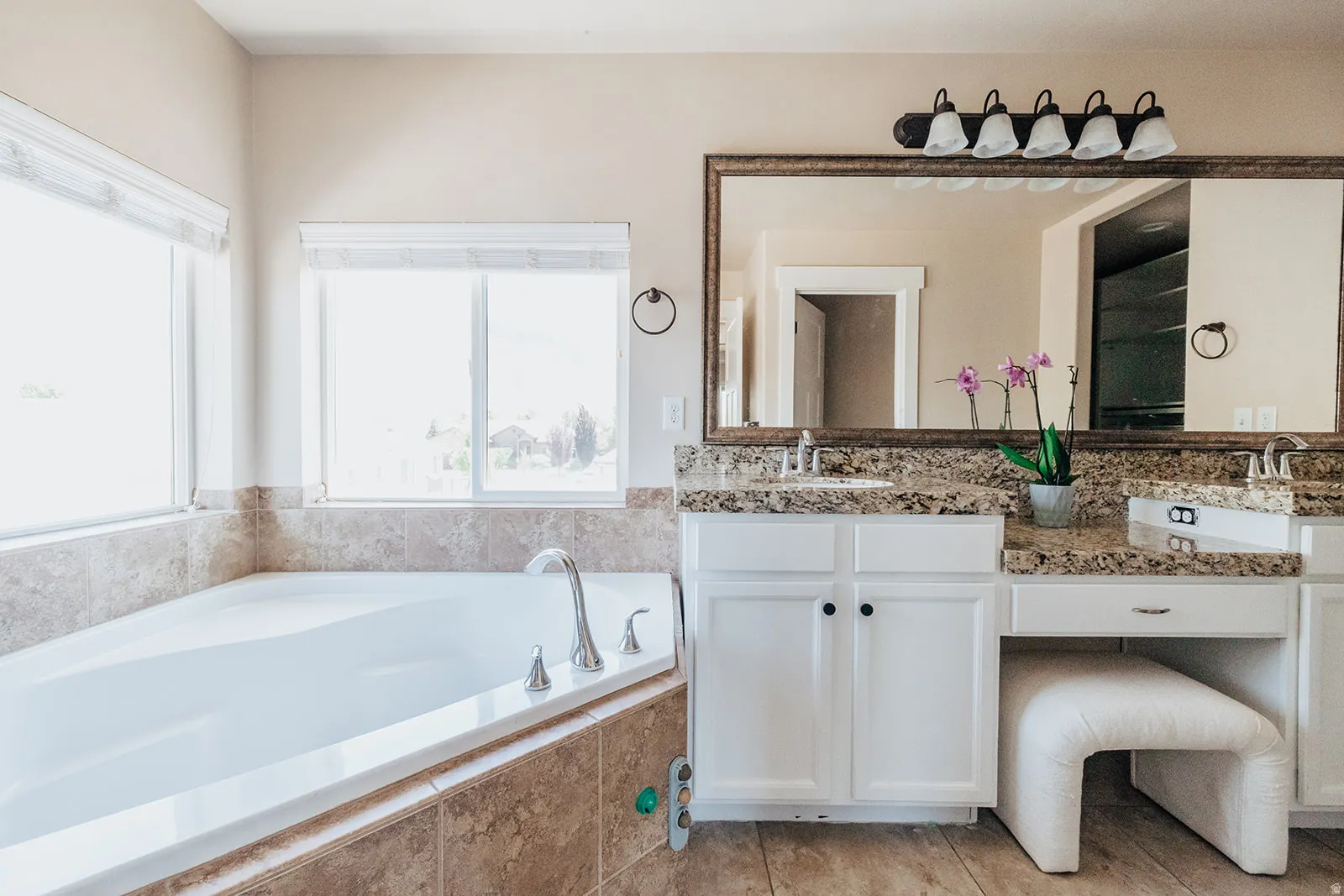 Corner soaking tub with tiled surround and multiple windows