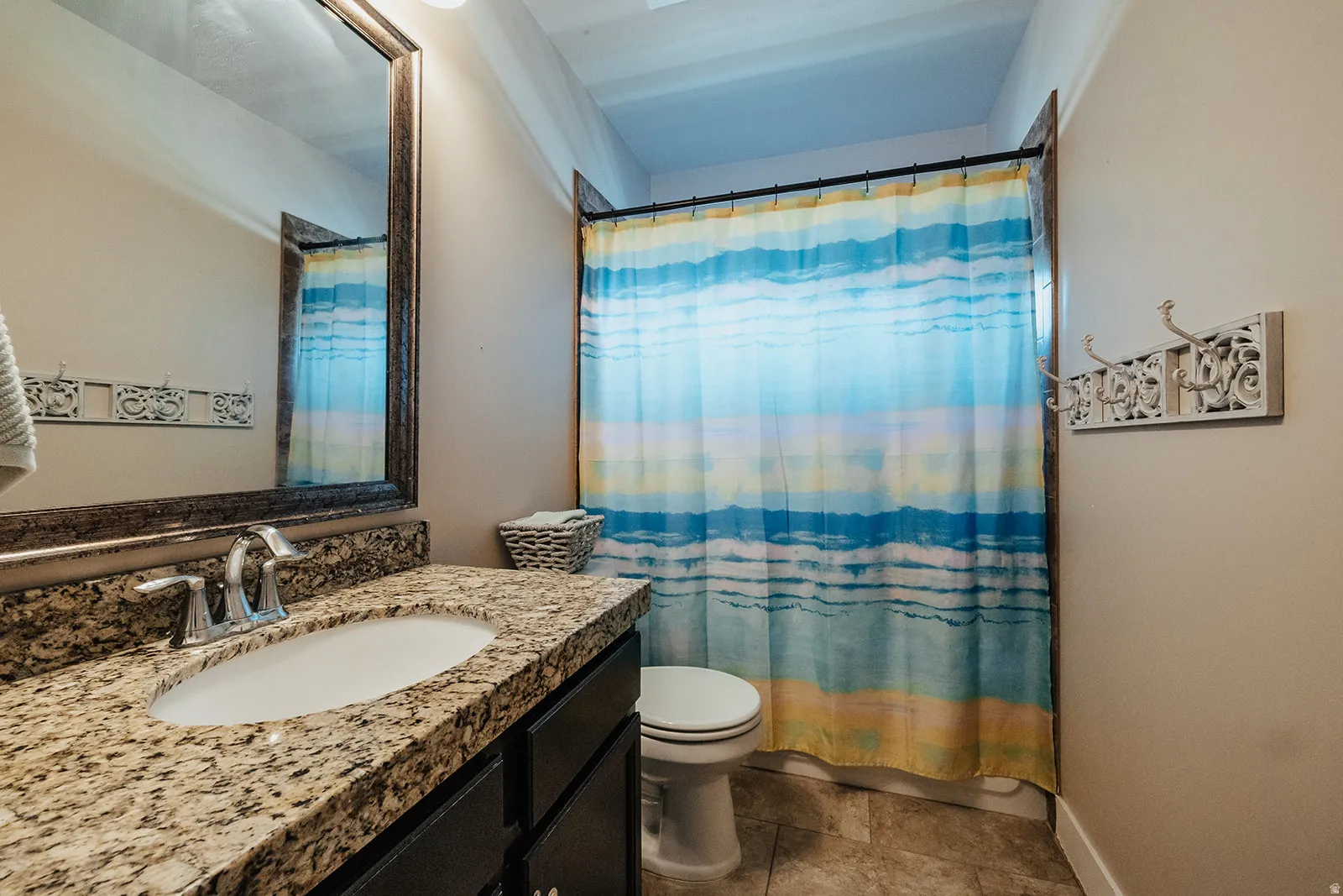Bathroom featuring a vanity with a granite-look countertop and an undermount sink