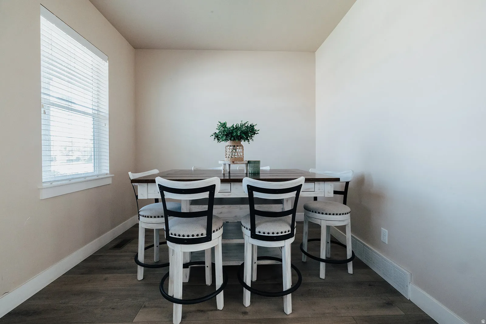 Recessed dining area featuring wood-finish flooring, a window with blinds, and light-toned walls