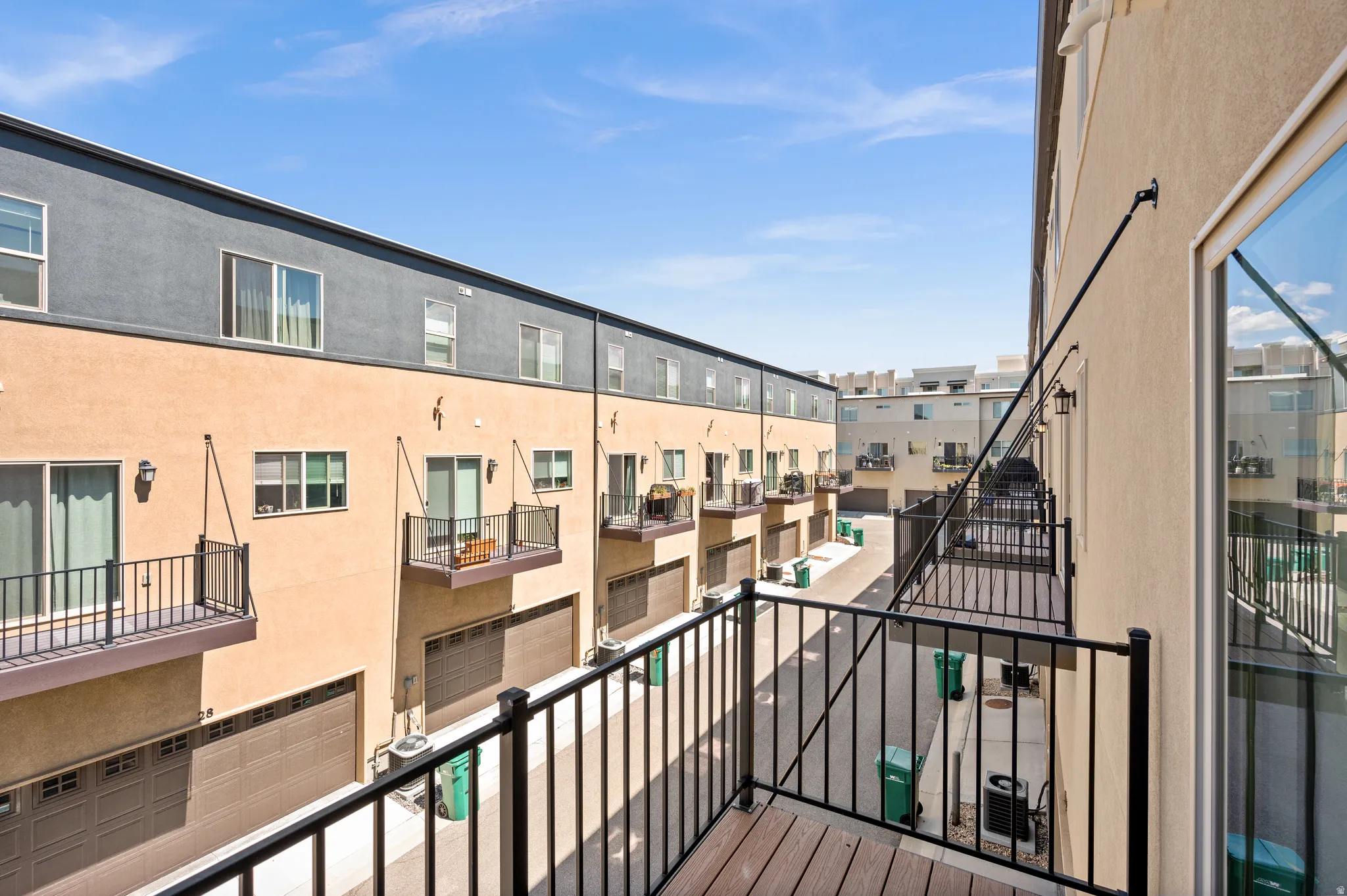 Private balcony with wood-finish decking and black metal railing