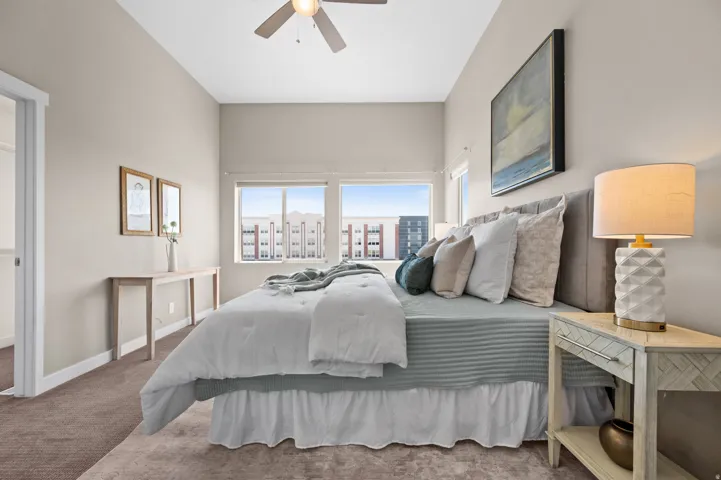 Neutral-toned room featuring a high ceiling, recessed lighting, and a ceiling fan