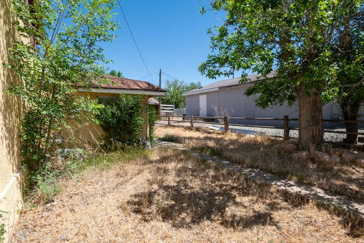 Exterior structure featuring a stucco finish, a covered entry, and a wood-slat fence