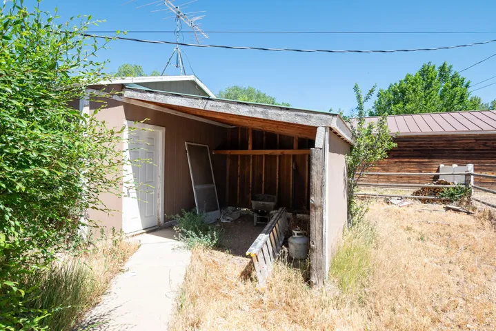 Outbuilding with attached covered storage area