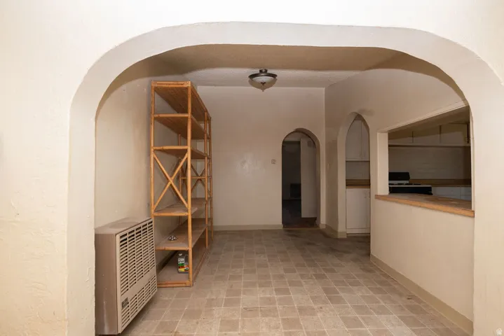 Interior space featuring multiple archways, a pass-through window, and checkered floor tiles