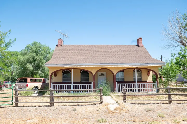 Single-story residence featuring a covered front porch with arched supports and a white spindle railing