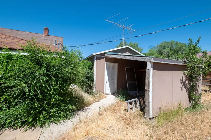 Detached outbuilding with a single entry door and covered porch area