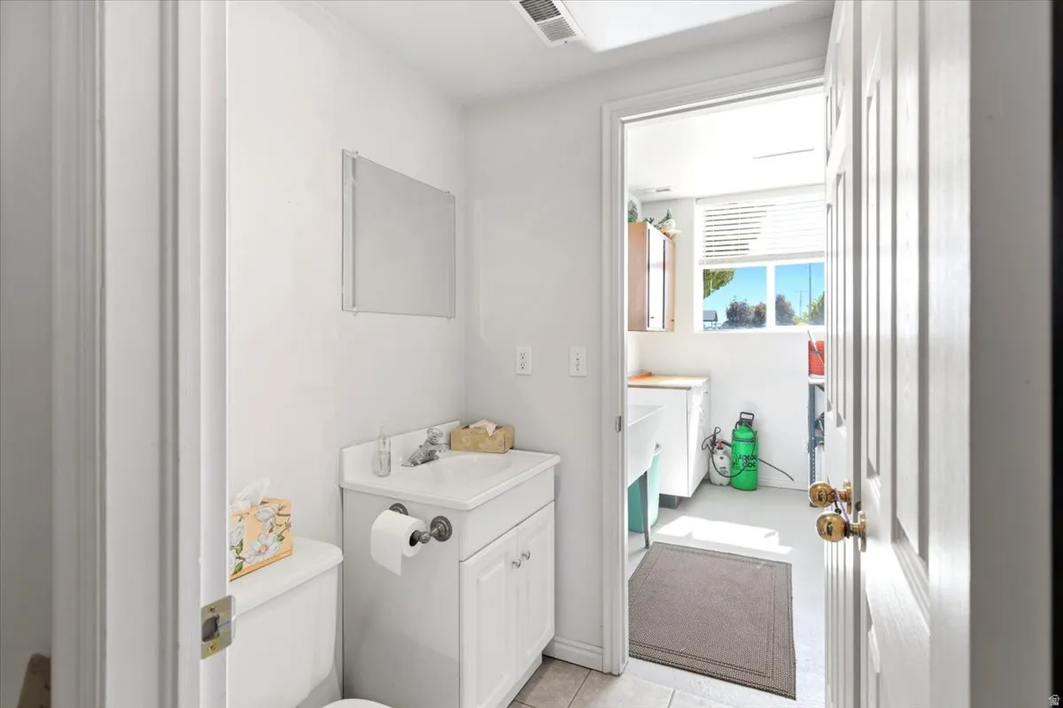White vanity with a laminate countertop, integrated sink, and brushed nickel faucet