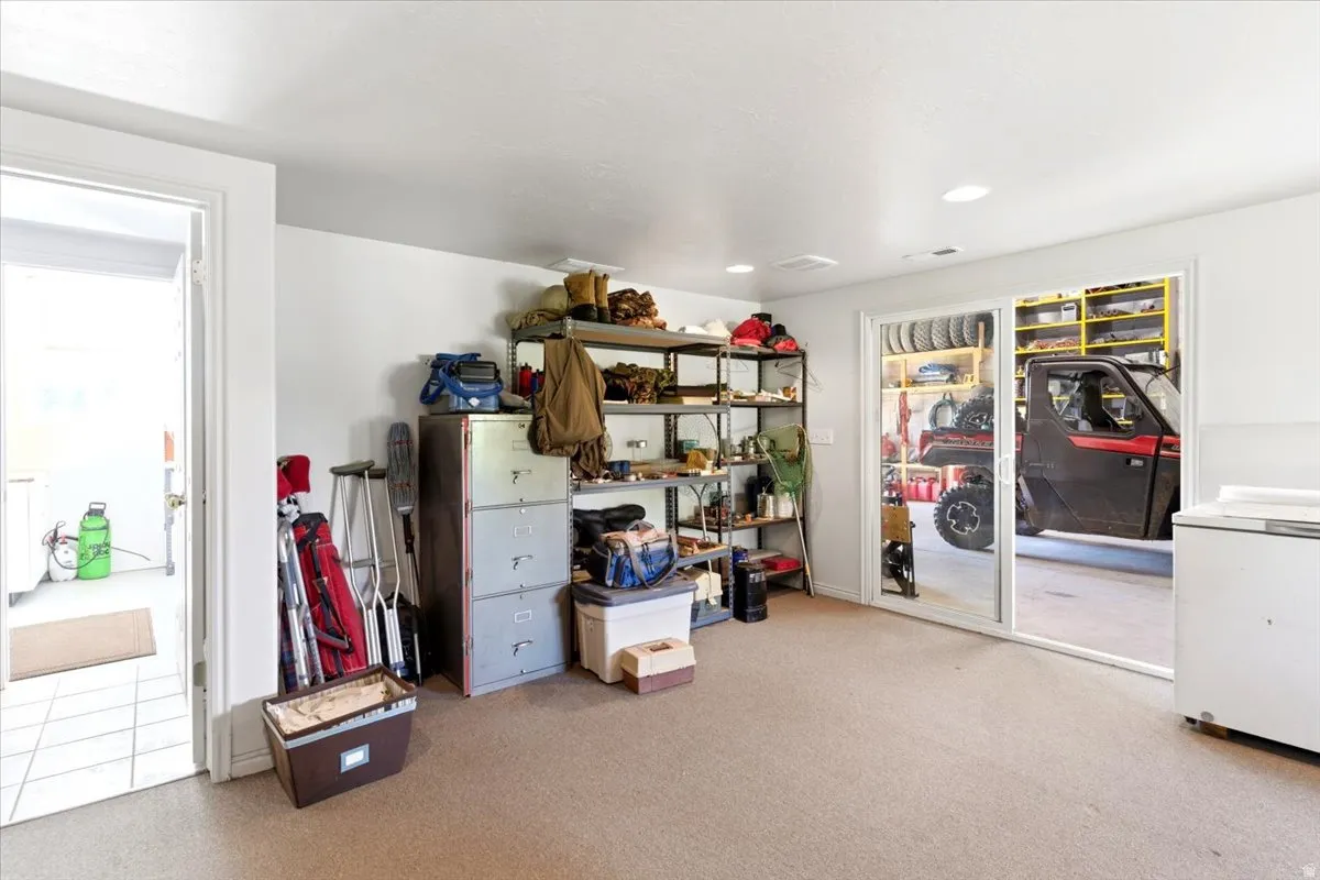 Spacious utility room featuring neutral carpeting and a large sliding glass door