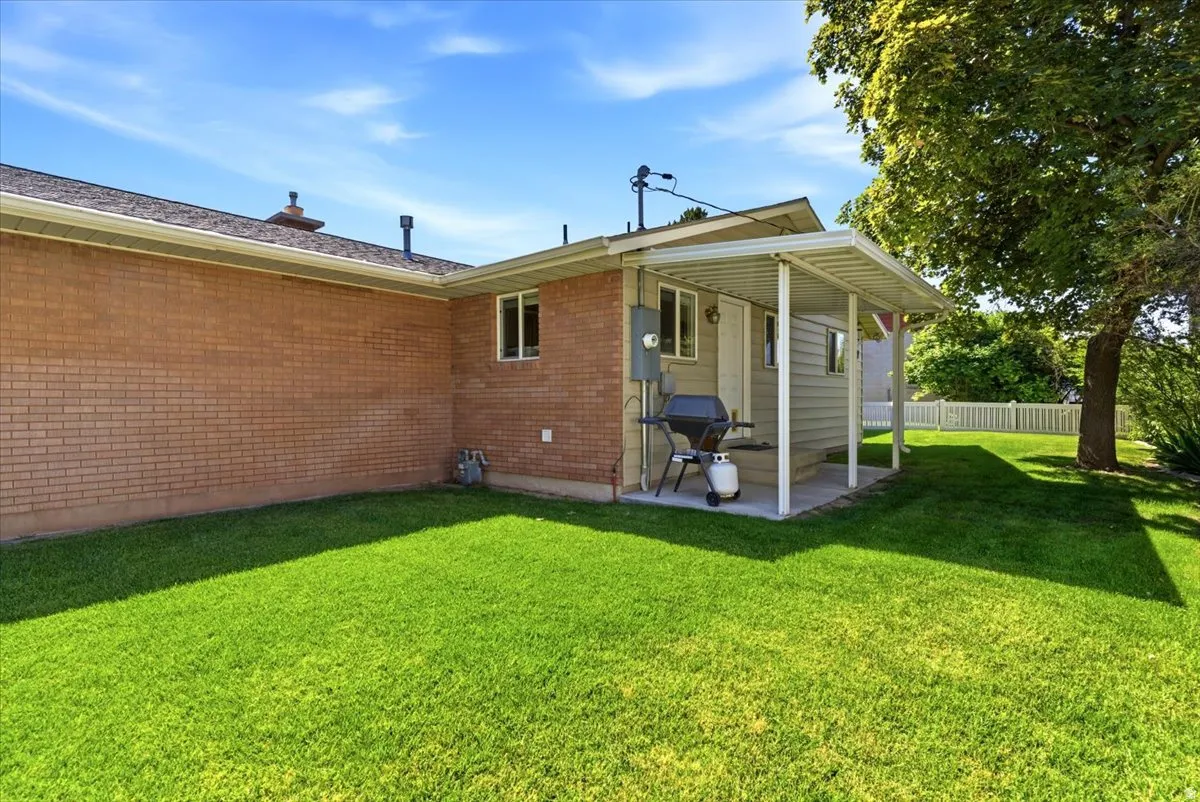 Expansive green lawn bordering a brick exterior with a covered patio area