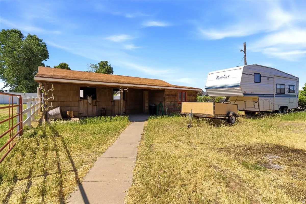 Barn structure with shingle siding and a tan shingle roof