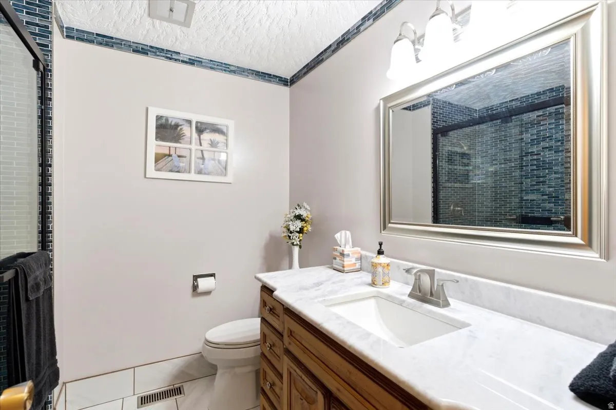 Bathroom featuring a single vanity with a white countertop and undermount sink