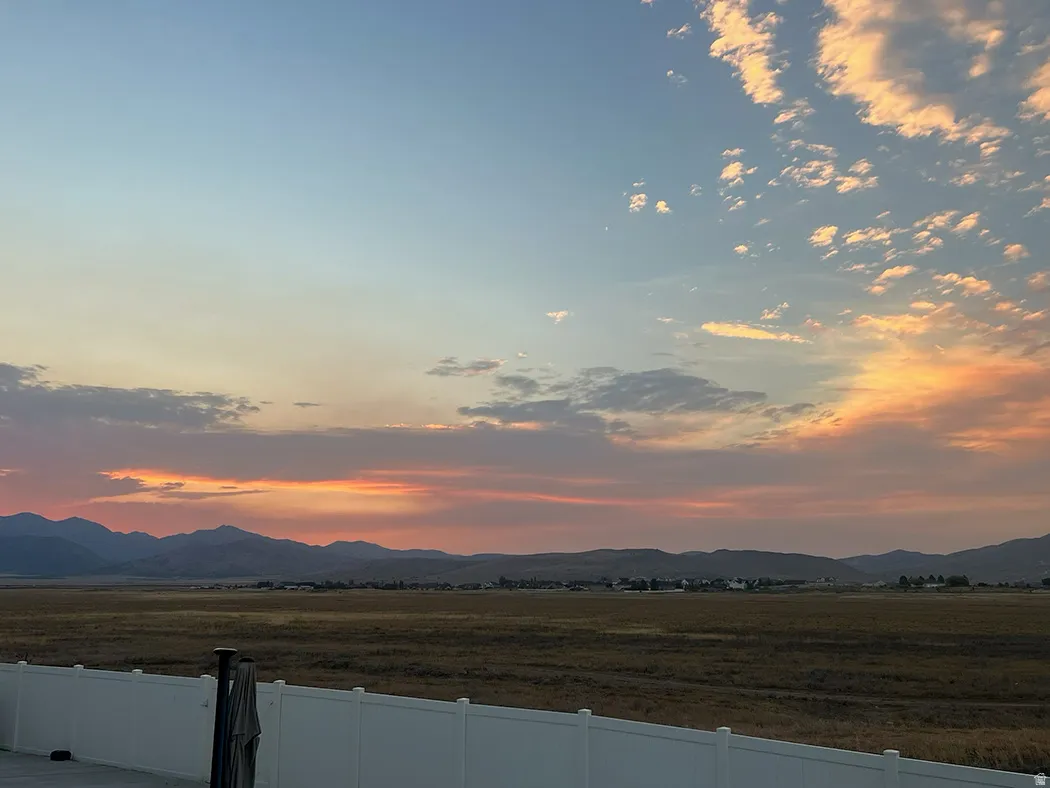 Expansive natural landscape with distant mountains under a colorful sky