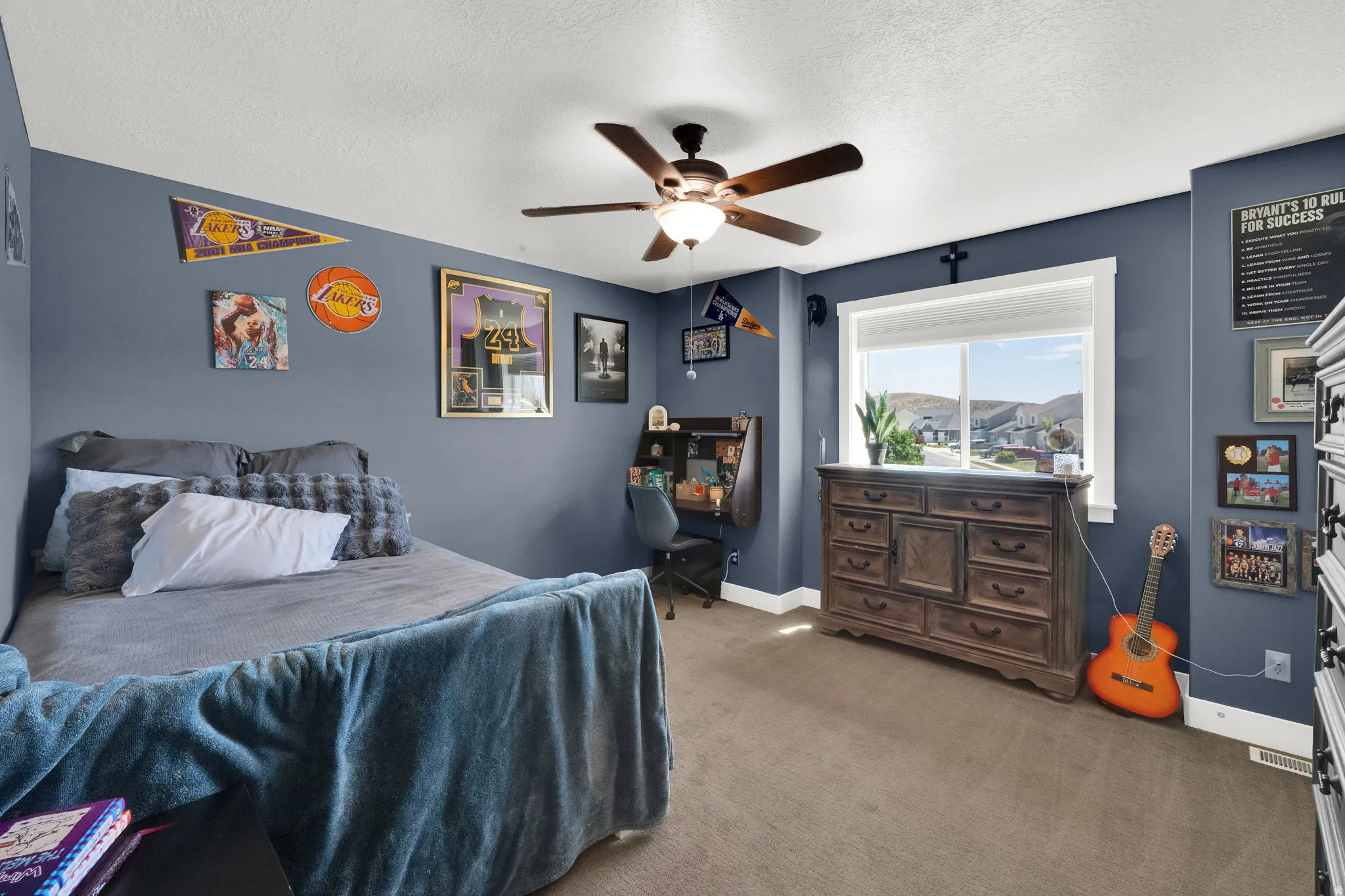 Spacious room featuring carpeting, a ceiling fan with integrated lighting, and a large window providing natural illumination