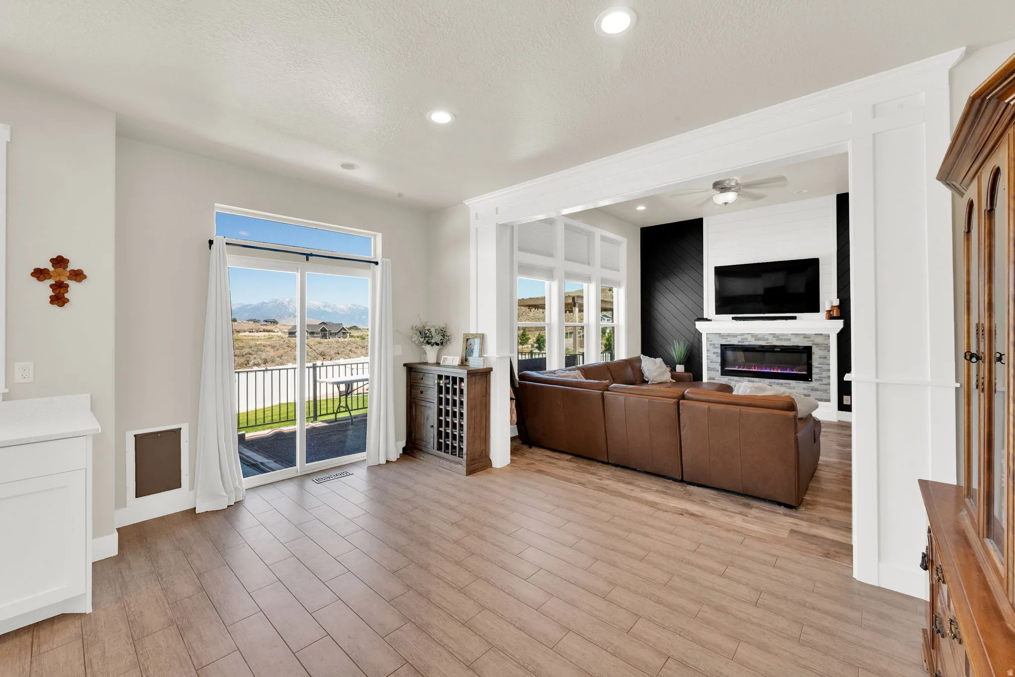 Open-concept living area featuring wood-finish flooring, recessed lighting, and a sliding glass door to an outdoor deck