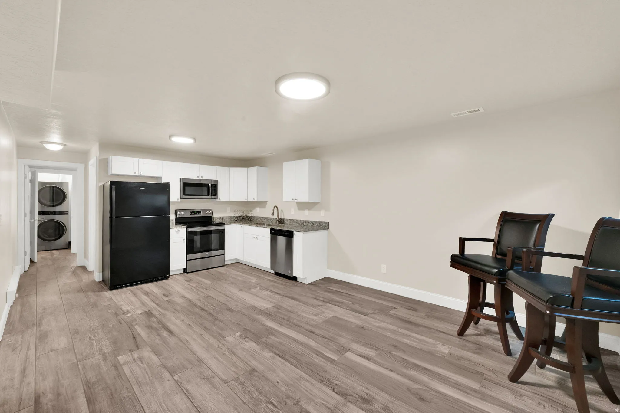 Open-concept living area featuring wood-finish flooring and recessed lighting