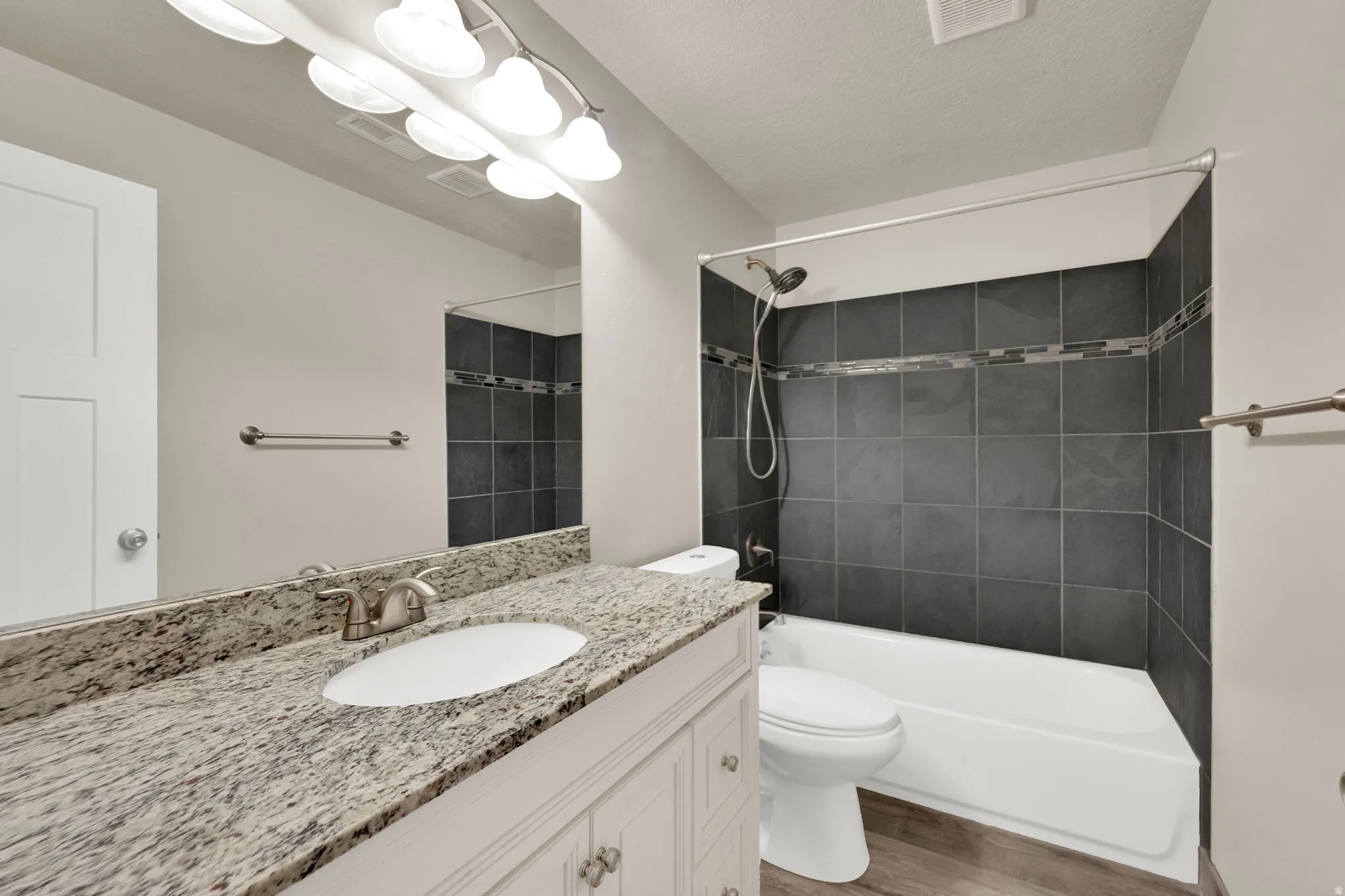 Vanity with a light-toned countertop, under-mount sink, and brushed nickel faucet