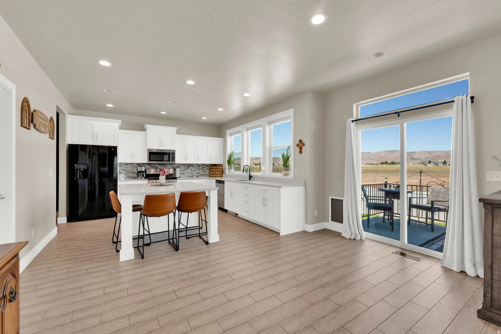 Spacious kitchen with a central island, recessed lighting, and wood-finish flooring