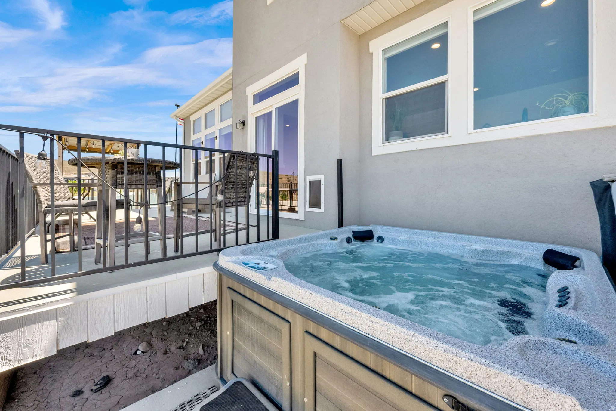 Outdoor spa with a multi-level deck, stucco exterior, and white-framed windows