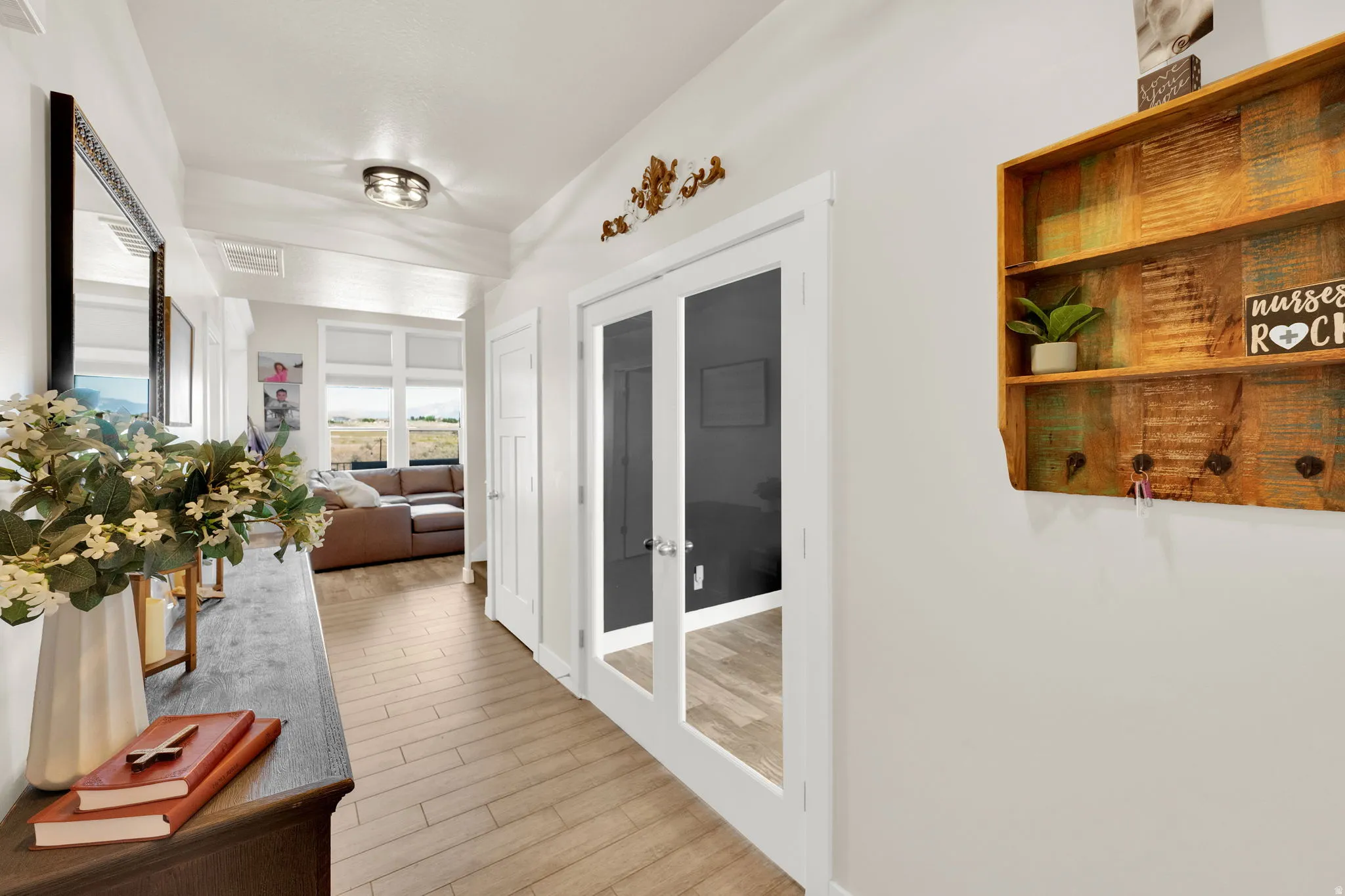 Hallway featuring wood-finish flooring, white walls, and a contemporary flush-mount ceiling light