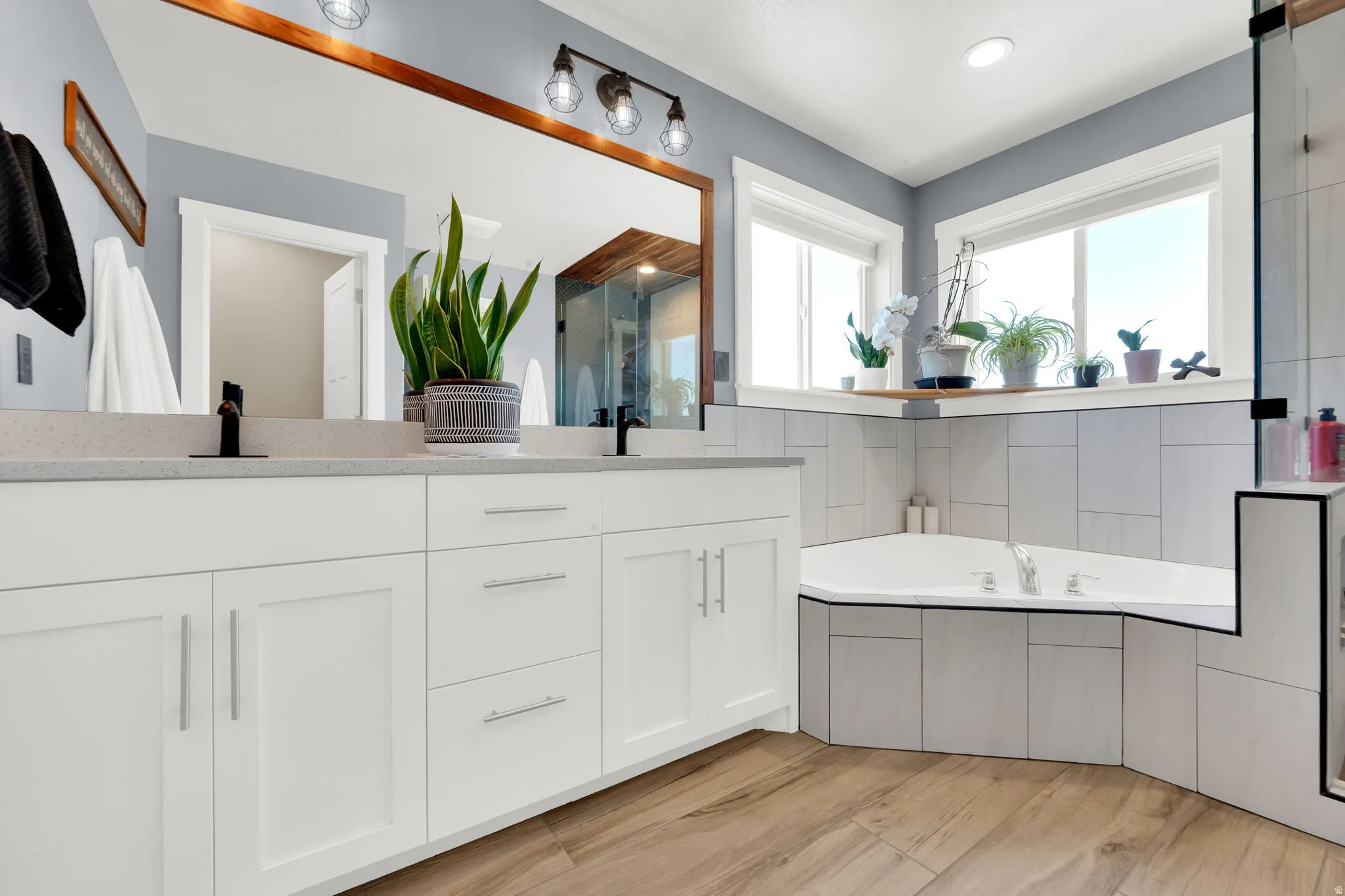 Dual vanity with white cabinetry, light-toned countertops, and matte black fixtures