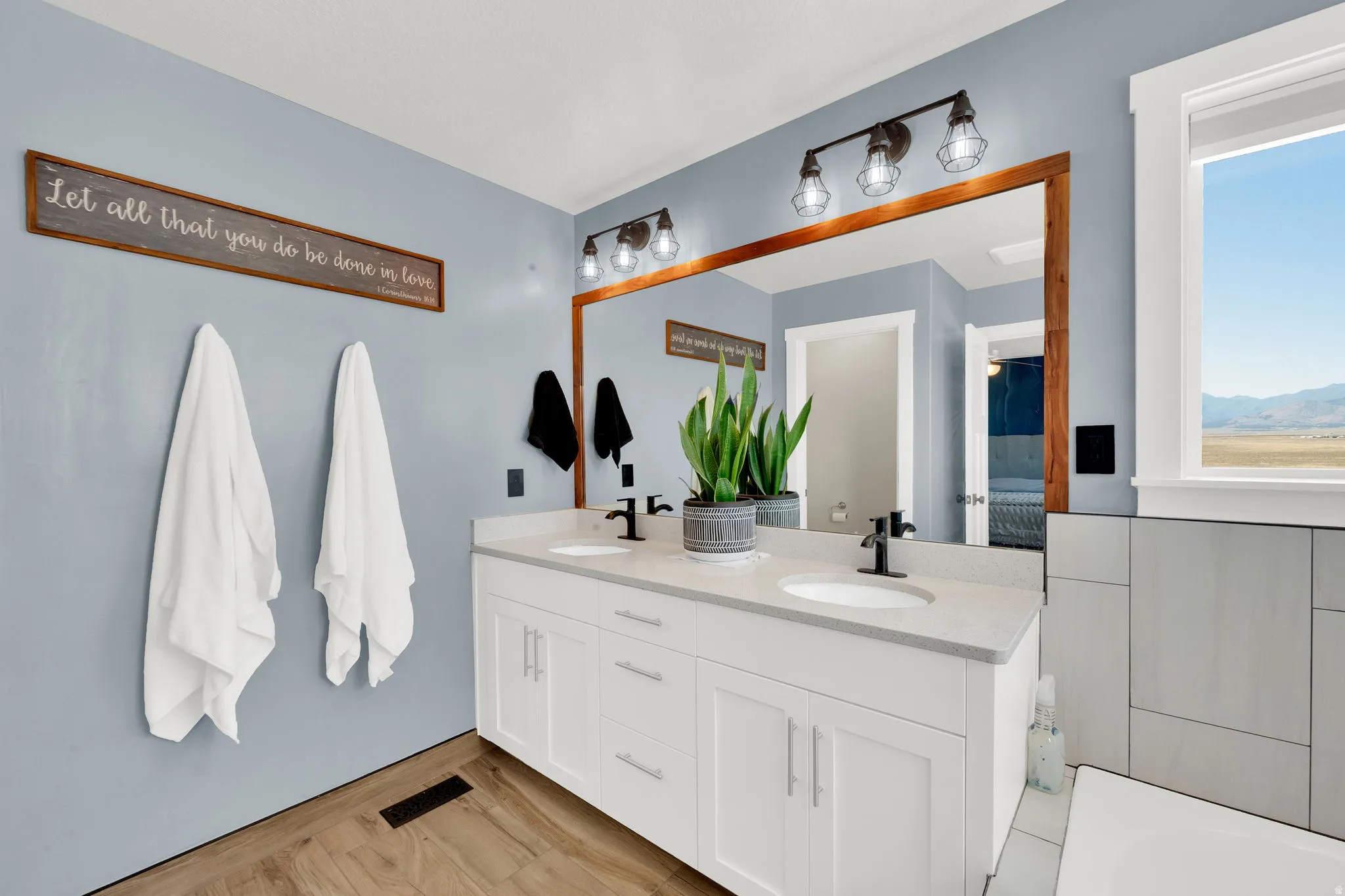Dual sink vanity with white cabinetry and light-toned countertops