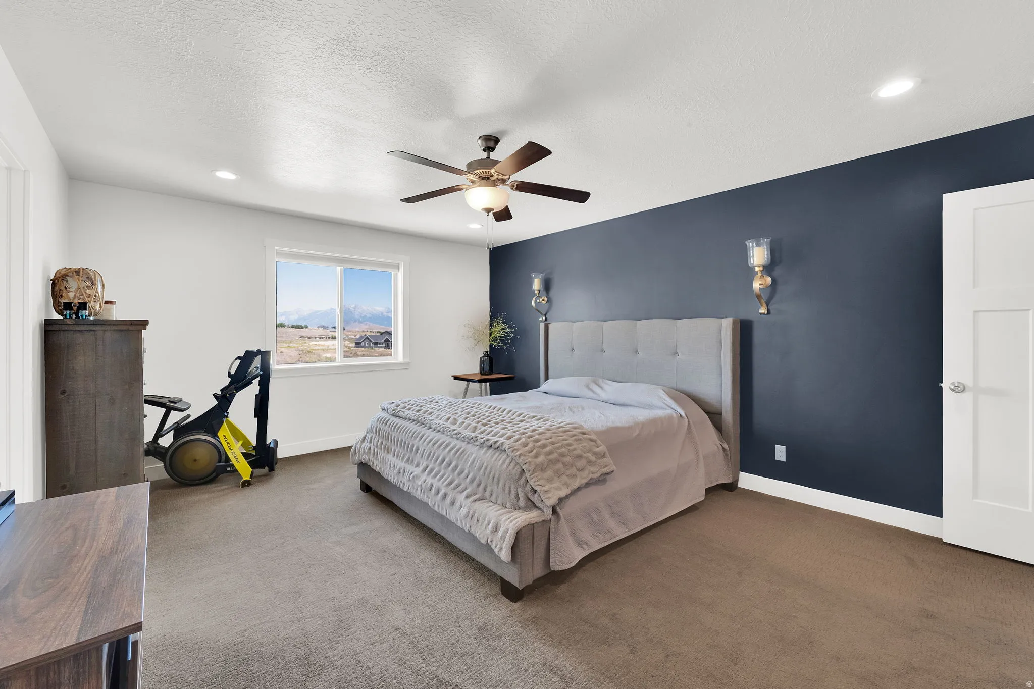 Carpeted room featuring a window with expansive distant scenery, a ceiling fan with integrated lighting, and recessed ceiling lighting