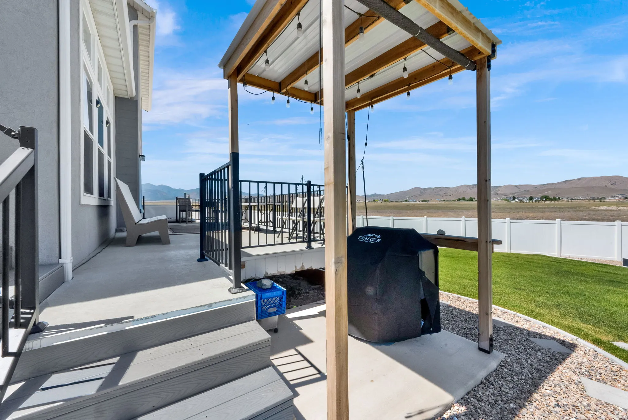 Expansive concrete patio area with a covered outdoor cooking space