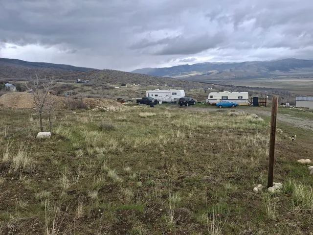 Expansive undeveloped lot featuring a natural grassland expanse and distant mountain range