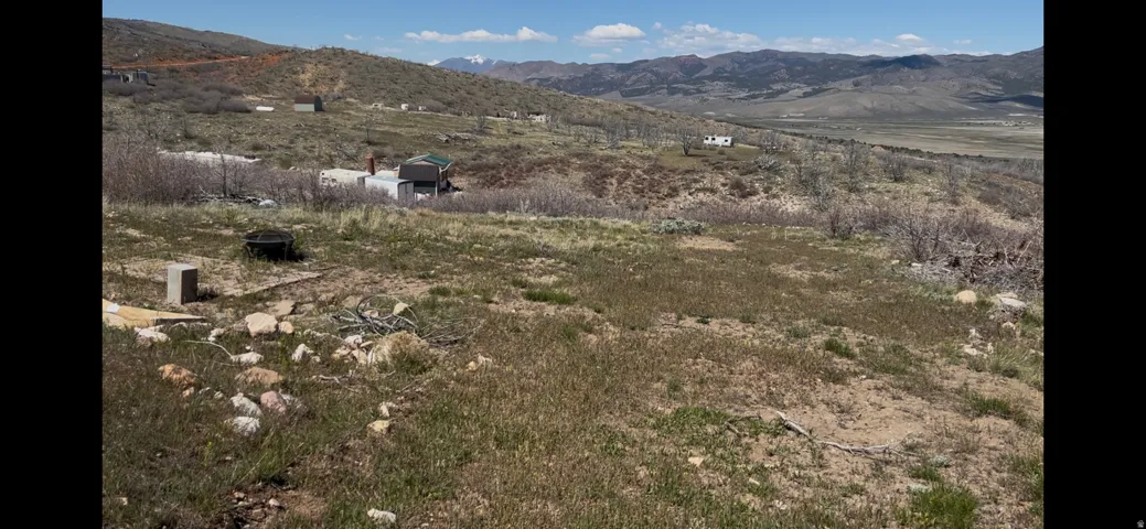 Expansive undeveloped land featuring varied terrain and distant mountain ranges under a clear sky