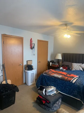 Carpeted room featuring light-colored walls and a ceiling fan with integrated lighting