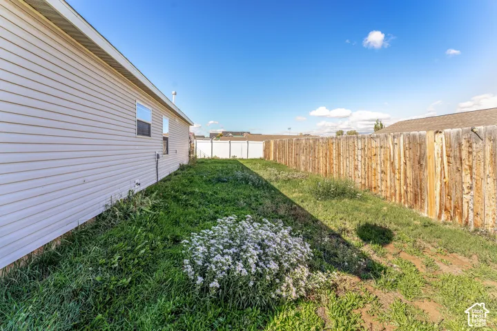 Vinyl siding exterior featuring a natural wood privacy fence