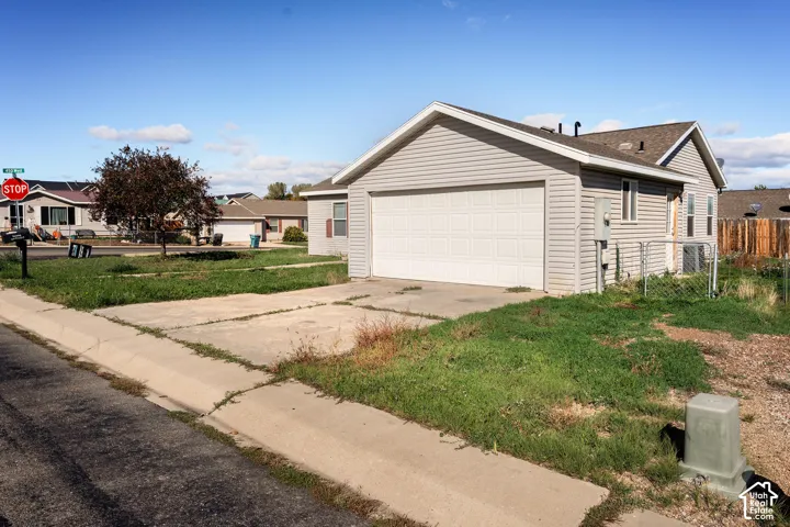 Exterior featuring light gray horizontal siding, an attached two-car garage, and a concrete driveway