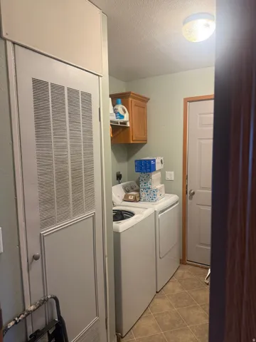 Dedicated laundry area featuring a top-load washer and front-load dryer