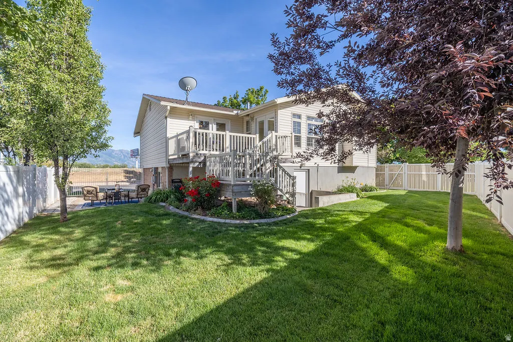 Expansive rear yard featuring a manicured lawn and mature trees