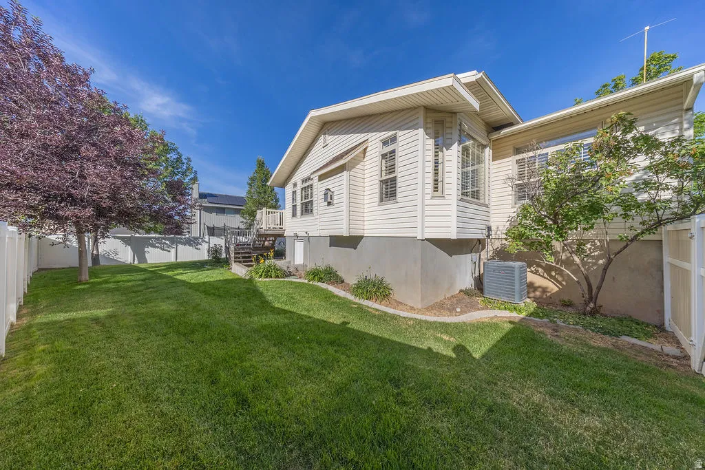Expansive rear yard featuring a manicured lawn and mature trees