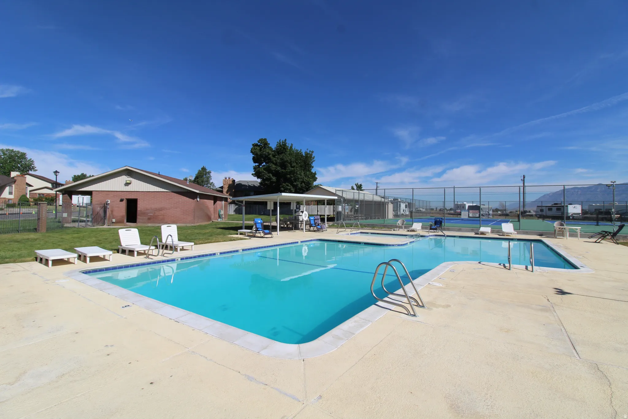 Community swimming pool featuring a concrete deck and integrated access steps