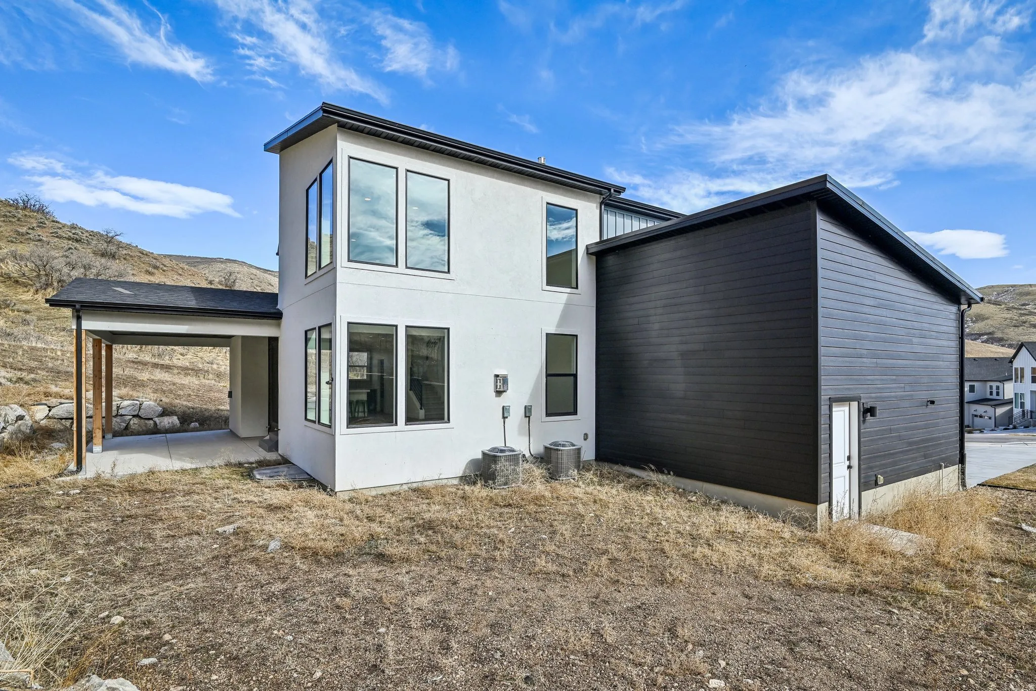 Modern exterior architecture featuring a white stucco facade and contrasting dark horizontal siding