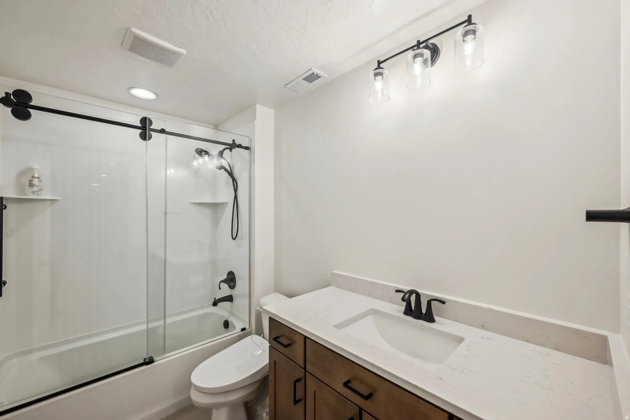 Bathroom featuring a full vanity with a built-in sink, stone-finish countertop, and wood-finish cabinetry