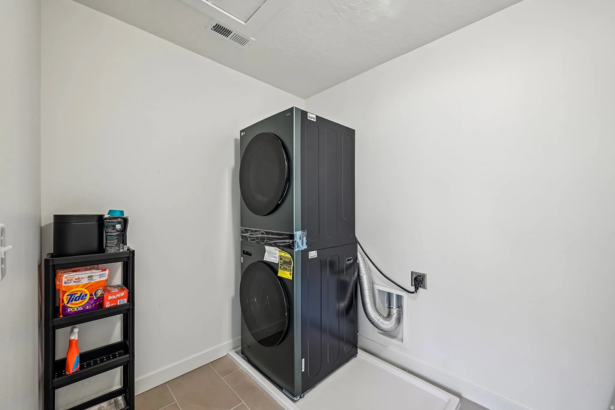 Dedicated laundry area featuring a stacked washer and dryer unit