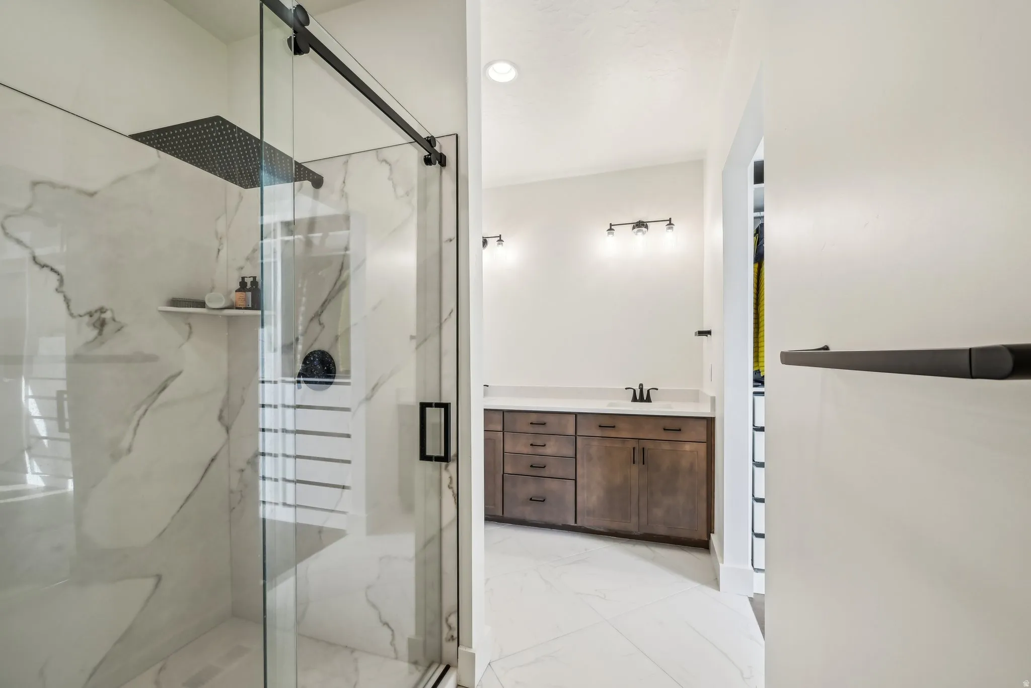 Shower with a sliding glass door, rain shower head, and an integrated shelf