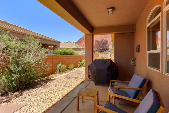 Covered patio featuring a concrete slab, exterior lighting fixture, and arched window