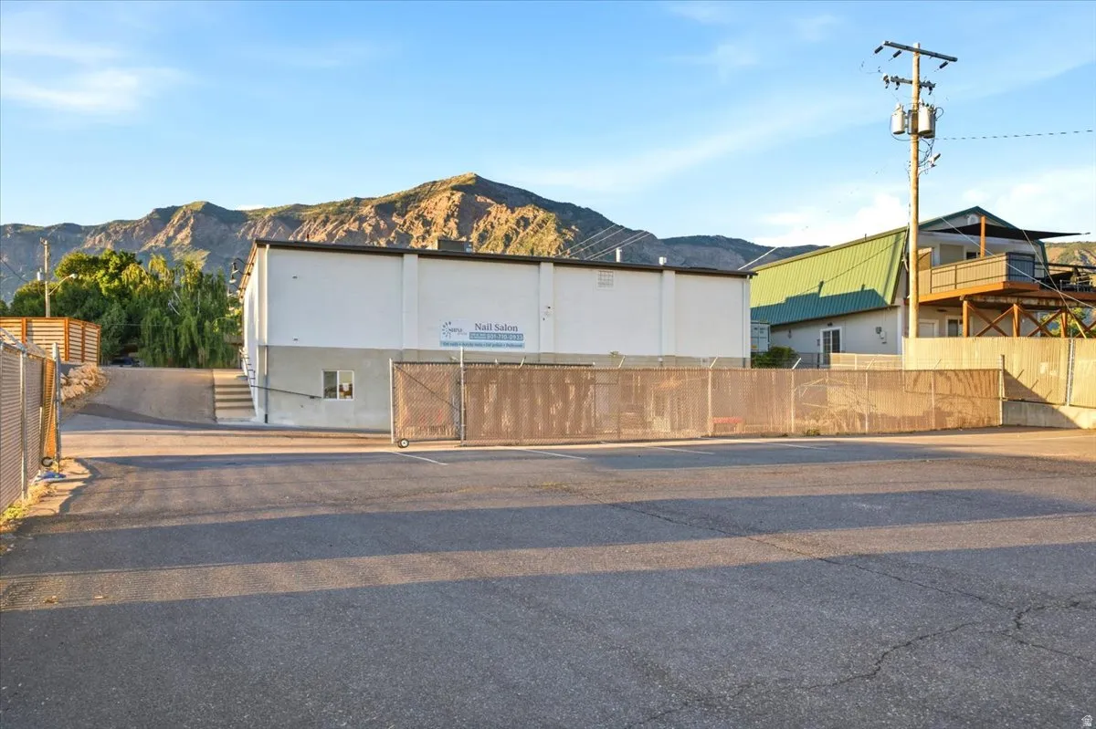 Expansive asphalt parking area featuring chain-link fencing
