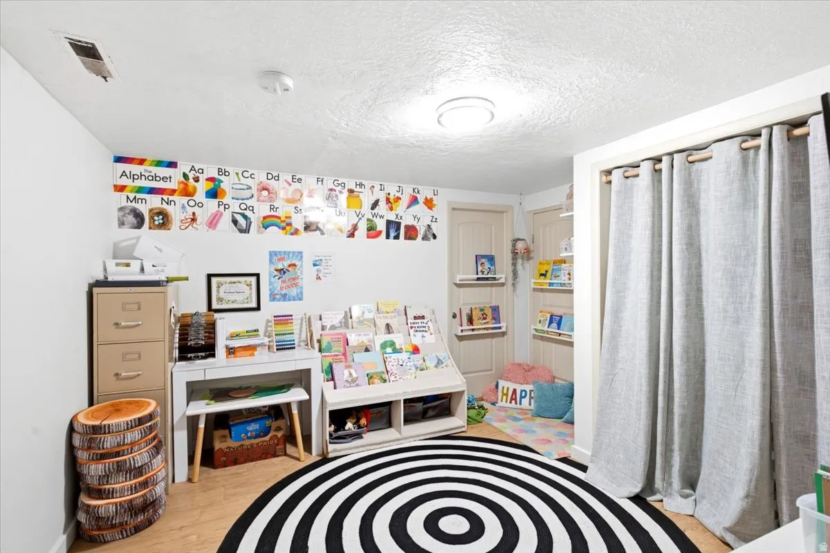 Versatile room featuring light wood-finish flooring, white walls, and two paneled interior doors