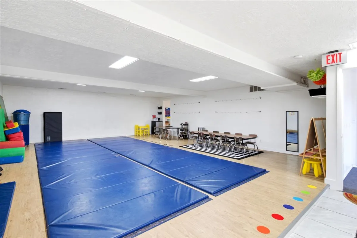 Spacious room featuring wood-finish flooring, recessed lighting, and a large open area