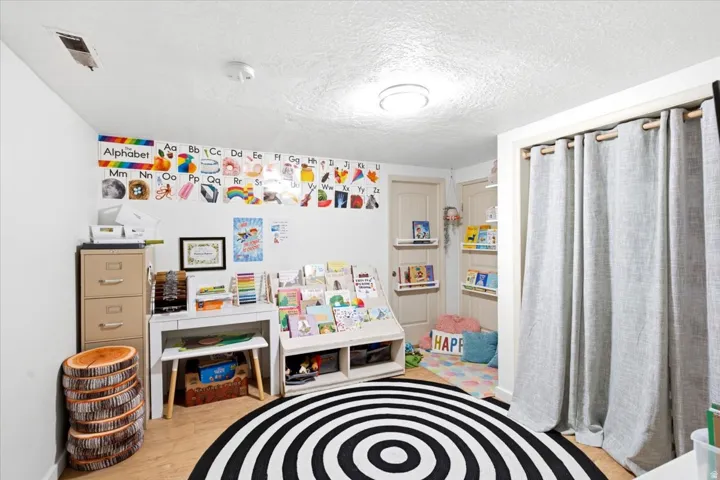 Versatile room featuring light wood-finish flooring, white walls, and two paneled interior doors