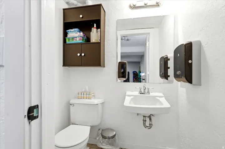 Compact bathroom with white textured walls