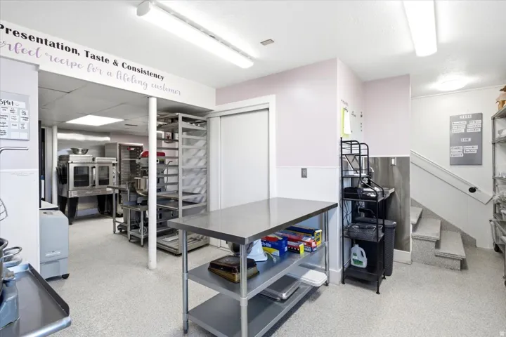 Commercial-grade kitchen space featuring speckled epoxy flooring and a stainless steel prep table