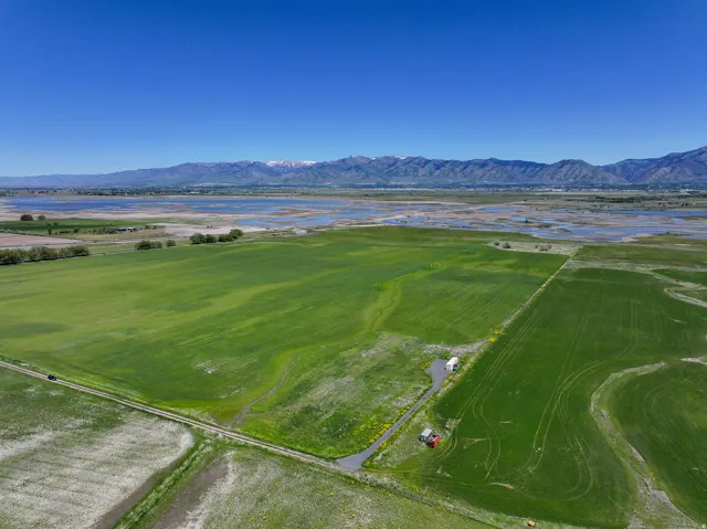 Expansive green fields with distant mountains and water features