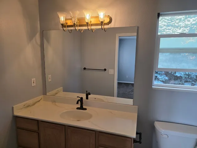 Bathroom vanity featuring a single basin, integrated countertop, and bronze-finish faucet